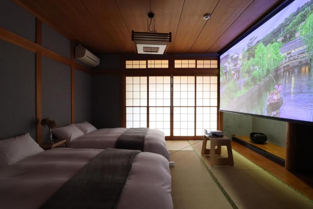 a bedroom with two beds and a large screen television at Samp,Inn - Vacation STAY 27372v in Fukuoka