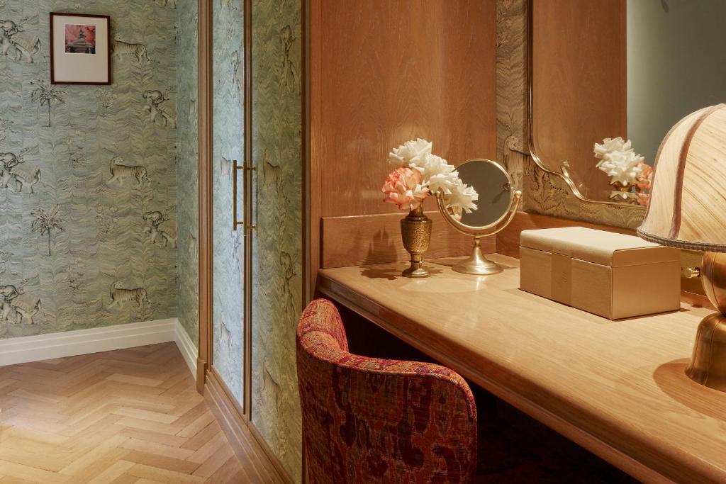 a room with a desk with a mirror and a chair at Broadwick Soho in London