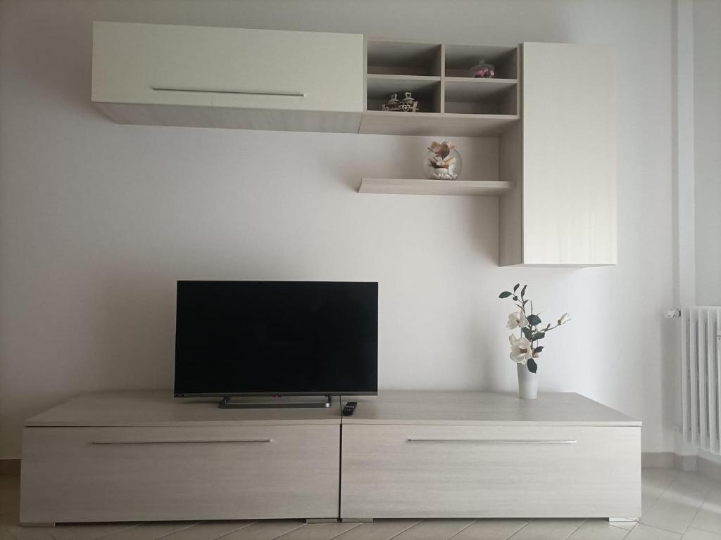 een woonkamer met een flatscreen-tv op een dressoir bij Appartamento Sara in San Donato Milanese