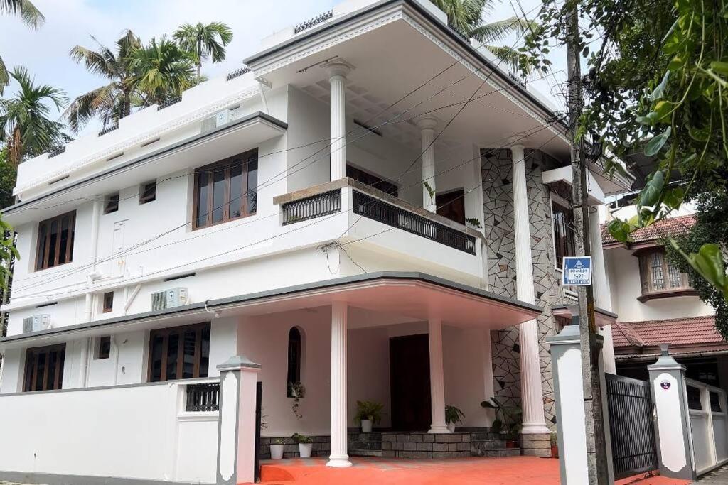 科欽的住宿－Hosted by Resmi Jayalal，街道上一座大型白色建筑,设有阳台