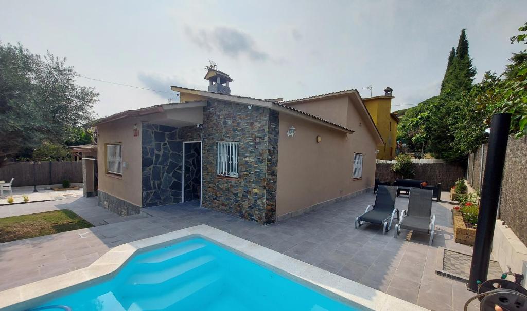 una casa con piscina frente a una casa en Casa parque Natural Montseny con piscina, barbacoa y Chimenea, en Sant Antoni de Vilamajor