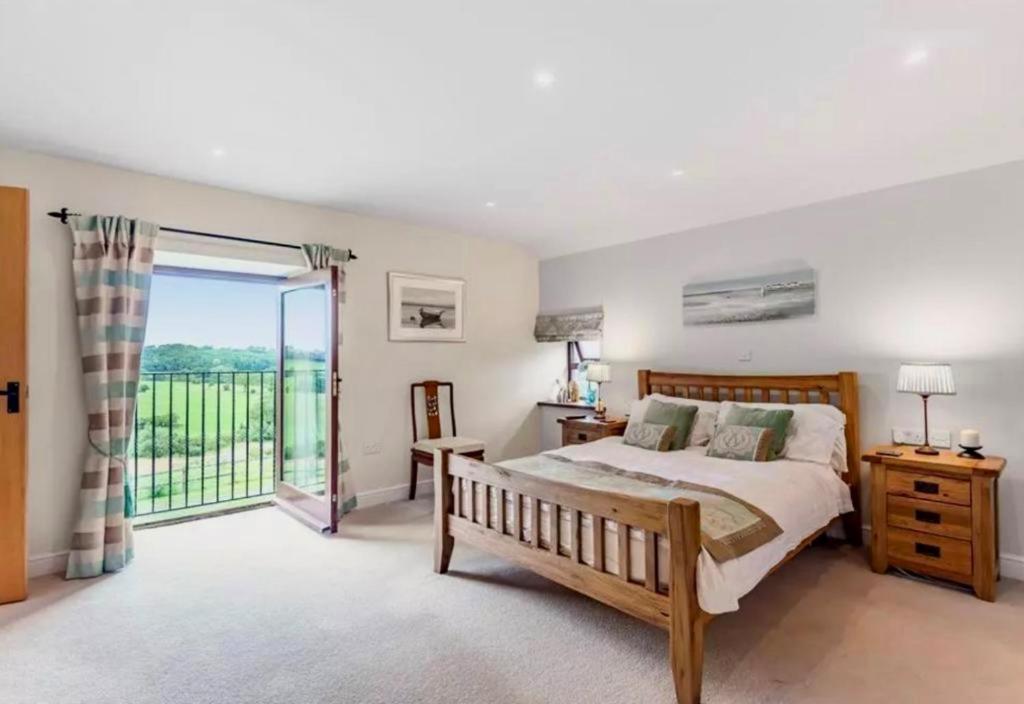 a bedroom with a bed and a sliding glass door at Booth House in Elslack