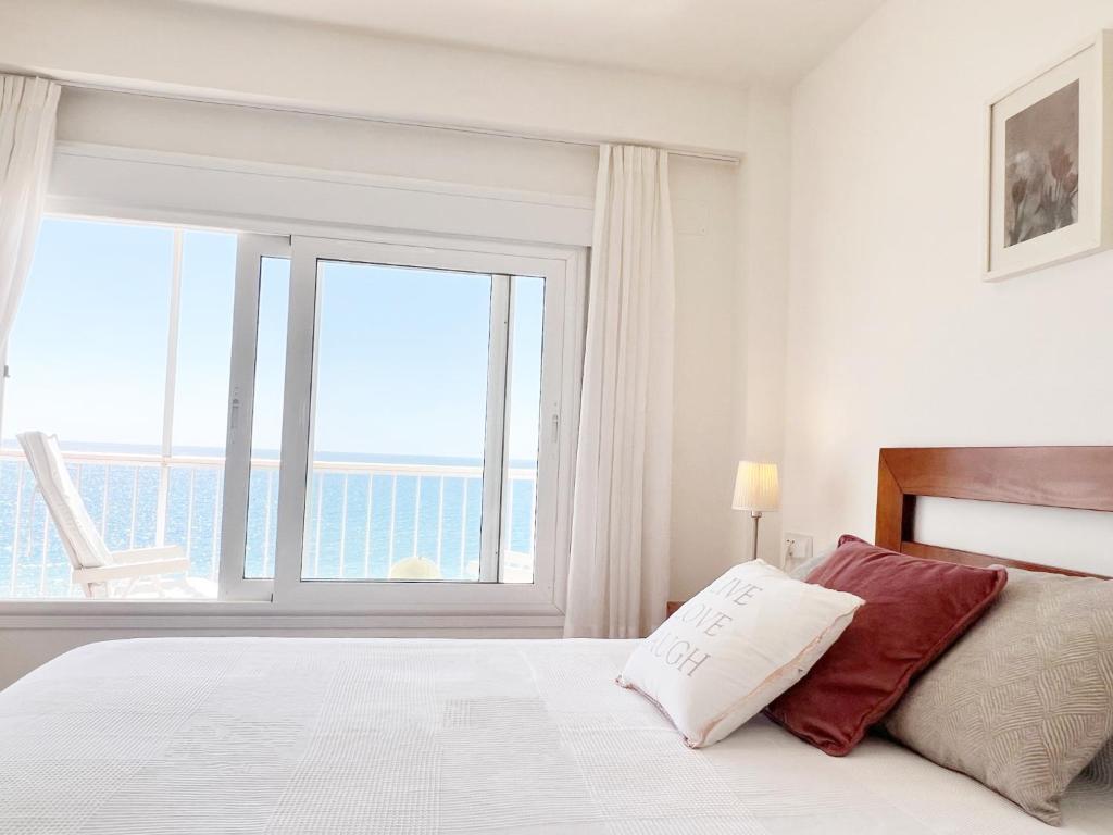 a white bedroom with a large window and a bed at Summerlandrota Cordoba8 in Rota