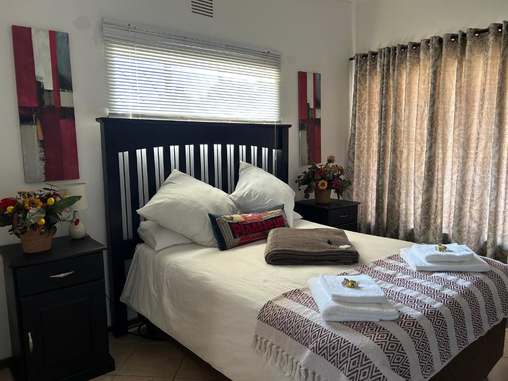 ein Schlafzimmer mit einem Bett mit zwei Handtüchern darauf in der Unterkunft 9 wena Ave Guesthouse in Klerksdorp
