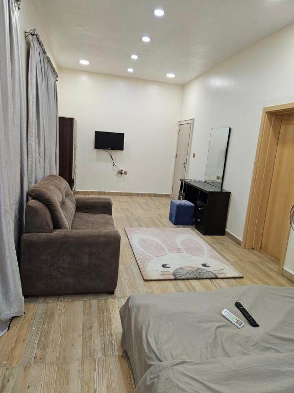 uma sala de estar com um sofá e uma televisão em KAMS Clubhouse Lifecamp, 24 power em Abuja