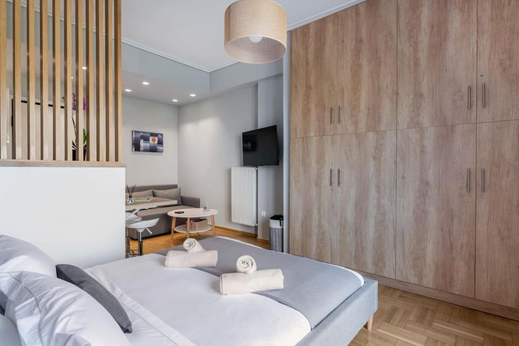 a bedroom with a large white bed and a living room at The HostMaster Vista Loft in Athens