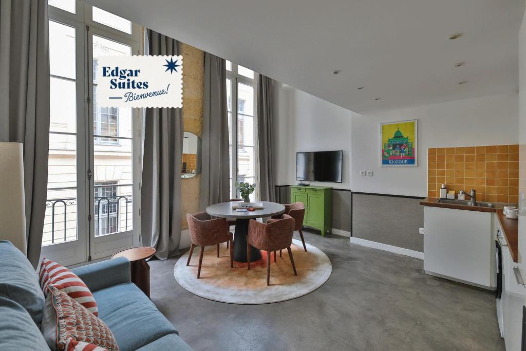 a kitchen and a living room with a table and chairs at Edgar Suites Louvre - Richelieu 2 in Paris