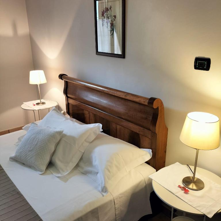 a bed with white sheets and pillows in a room at Stella d'Italia in Sparone