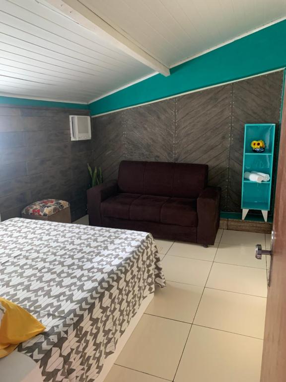 a living room with a bed and a couch at Hostel Morro de Sao Paulo in Salvador