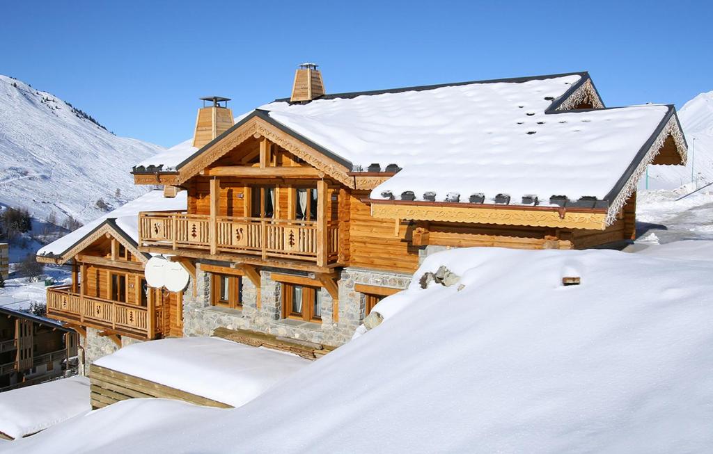 een blokhut in de sneeuw met een berg sneeuw bij Odalys Chalet Leslie Alpen 2 in Les Deux Alpes