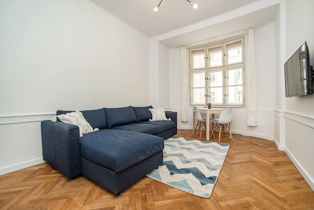 ein Wohnzimmer mit einem blauen Sofa und einem Tisch in der Unterkunft Cozy apartment in hipster area in Prag