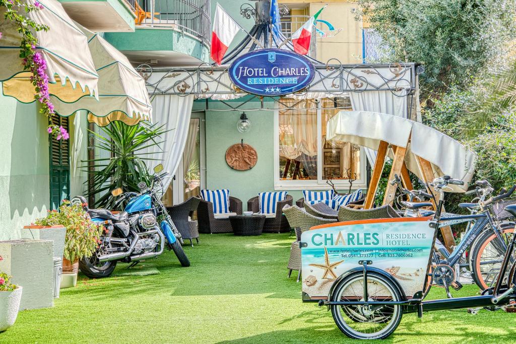 una bicicleta estacionada en el césped frente a un edificio en Hotel Residence Charles, en Rímini