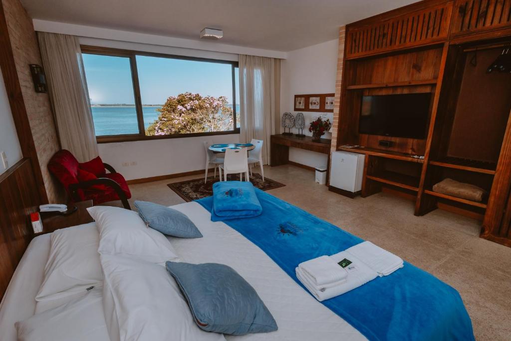 a bedroom with a large bed with a view of the ocean at Partner Itapoa by Marina in Itapoa