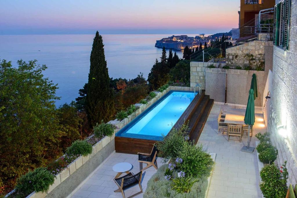 una piscina en la parte superior de un edificio con vistas al océano en Villa Grande Bukovca - Beautiful 5 bedroom villa - Sea views - Glamorous location en Dubrovnik