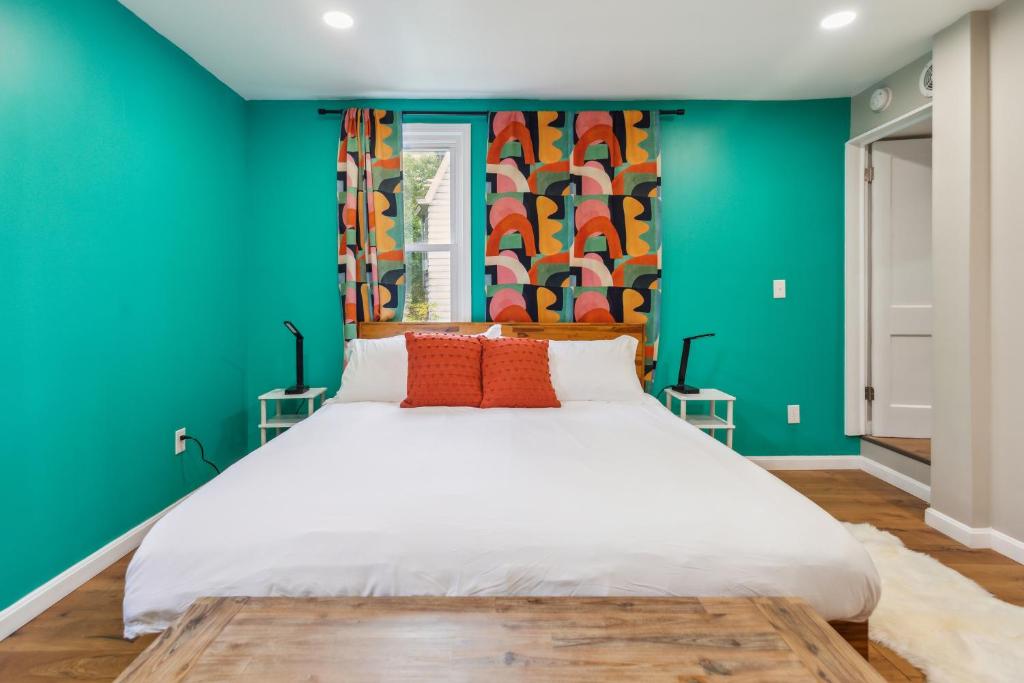 匹茲堡的住宿－Charming Remodeled 3-BR Bungalow near Attractions，卧室配有白色大床和绿色墙壁