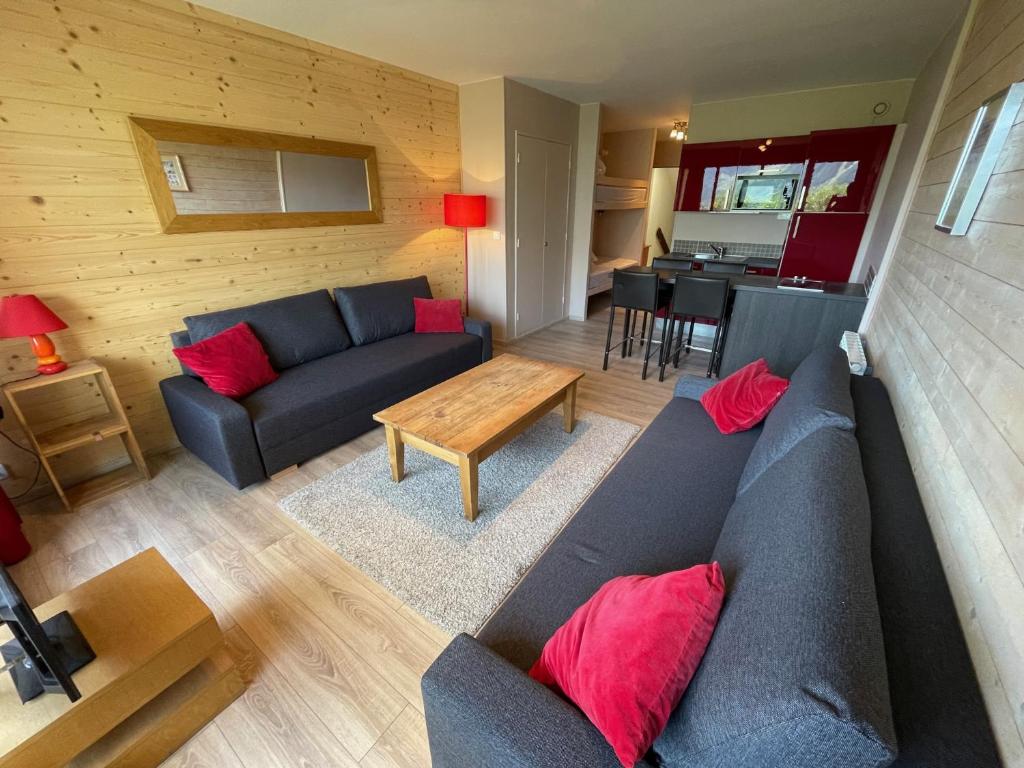 - un salon avec un canapé bleu et des oreillers rouges dans l'établissement Studio rénové 35 m² - 4/6 couchages - A coté des pistes - terrasse vue montagne, à Orcières