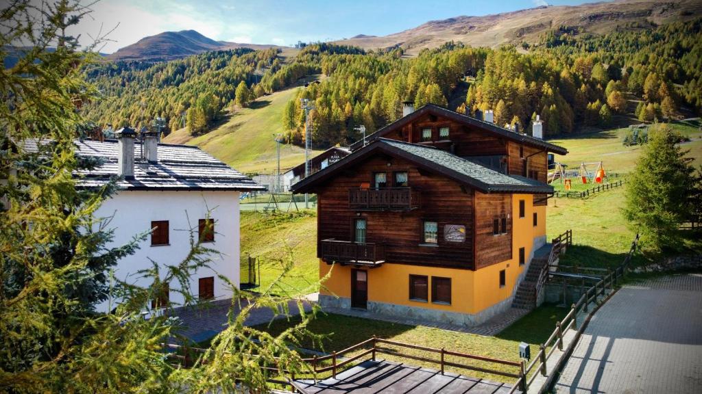 ein großes Holzhaus inmitten eines Berges in der Unterkunft Chalet Girasole in Livigno