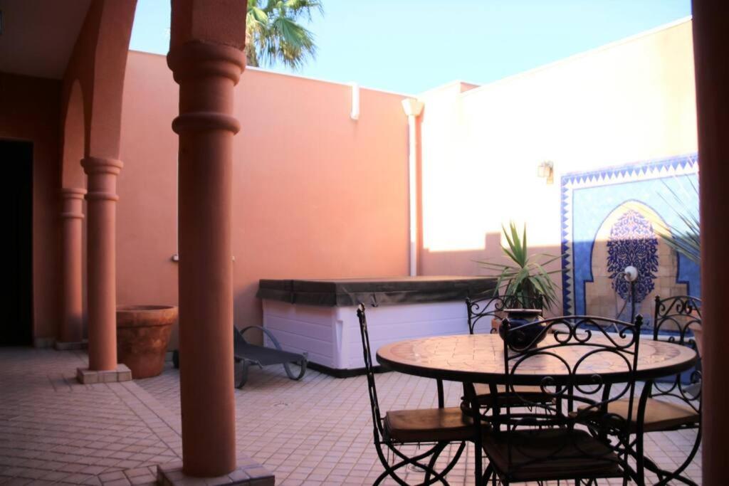 an outdoor patio with a table and chairs at Chambre Agdz, Riad 2 Couple only au village naturiste in Cap d'Agde