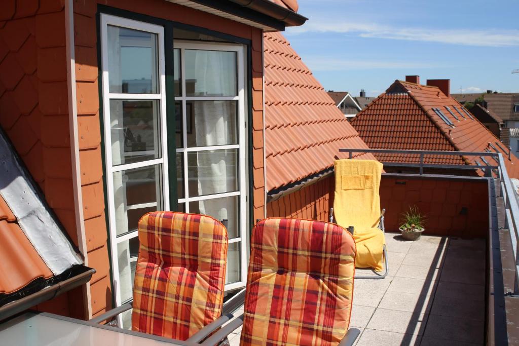duas cadeiras sentadas na varanda de uma casa em Nordseewind em Büsum