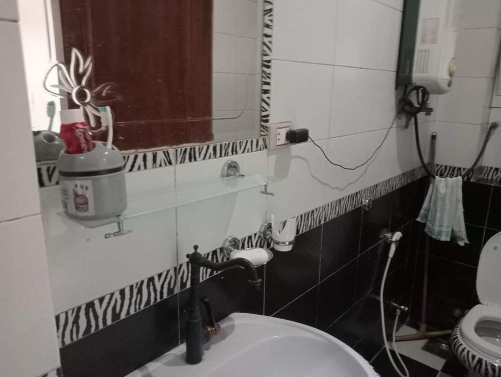 een badkamer met een toilet en een spiegel aan de muur bij شبرا مصر in Caïro