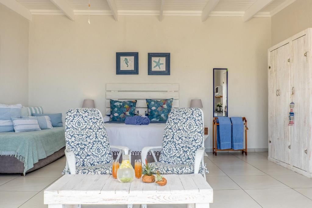 a living room with two chairs and a bed at Forever Blue in St. Helena Bay