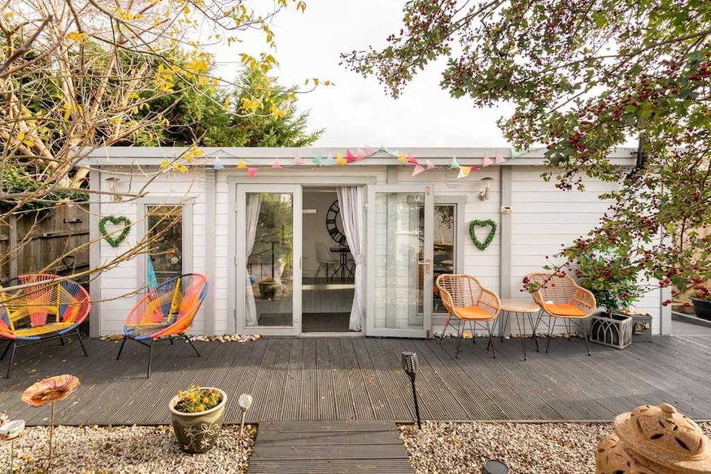 a patio with orange chairs and a table on a deck at The Cabin At The Beach in Seasalter