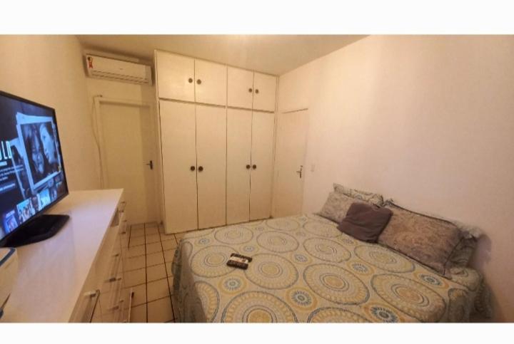 a small bedroom with a bed and a flat screen tv at Apartamento Barra in Salvador