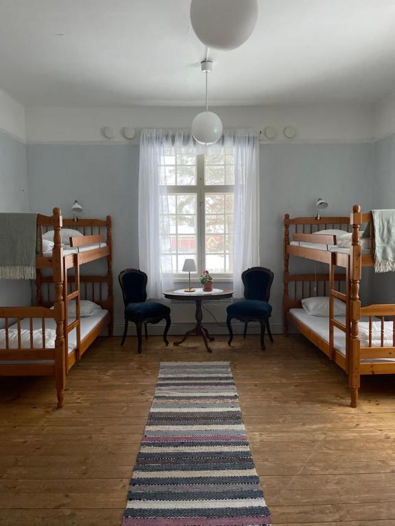 a room with bunk beds and a table and a table at Officersvillorna, Älvkarleby Vandrarhem in Älvkarleby