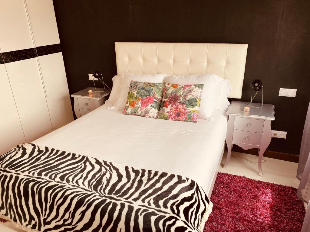 uma cama com estampa de zebra com duas almofadas em Los Respigos Laredo em Laredo