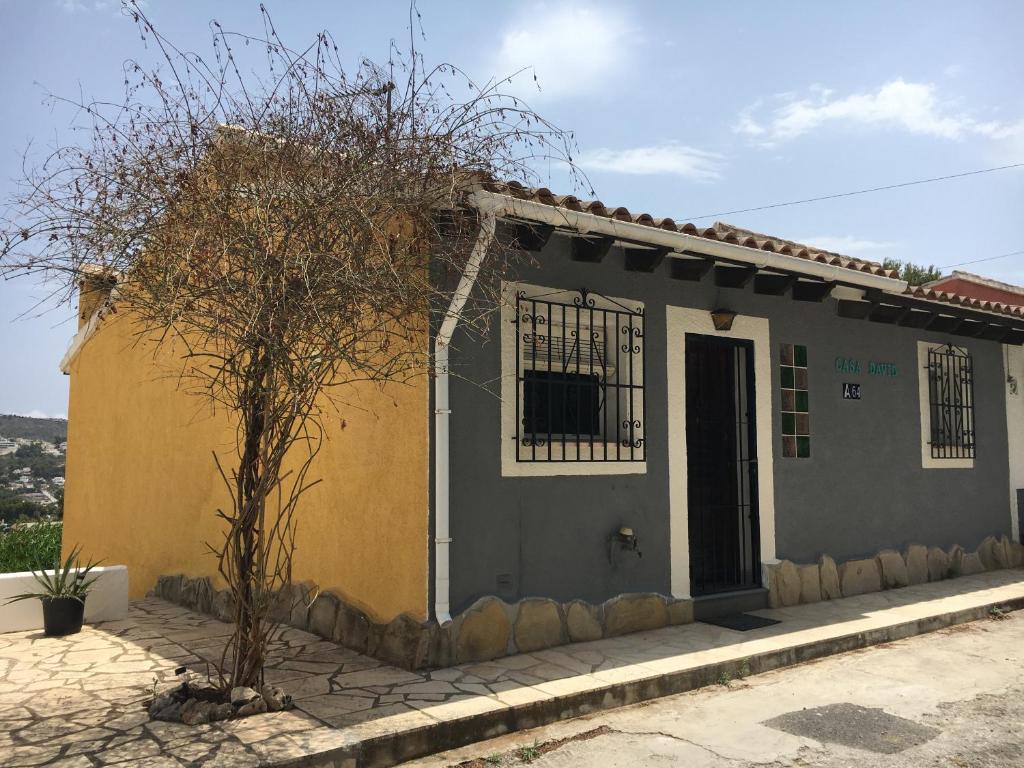 a small house with a tree in front of it at Casa David in Teulada