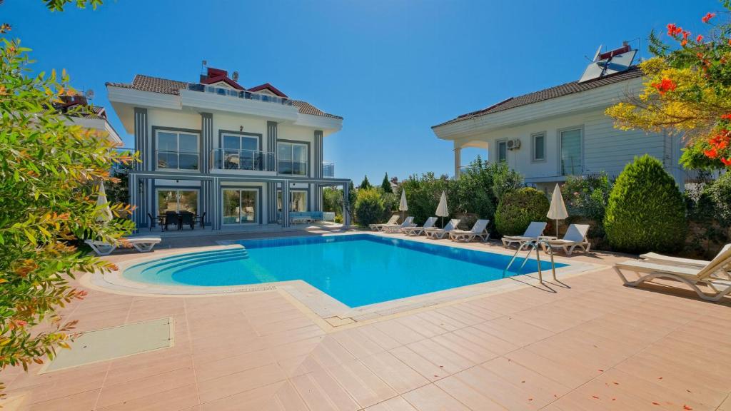 a swimming pool in front of a house at Orka Crystal Villa in Oludeniz