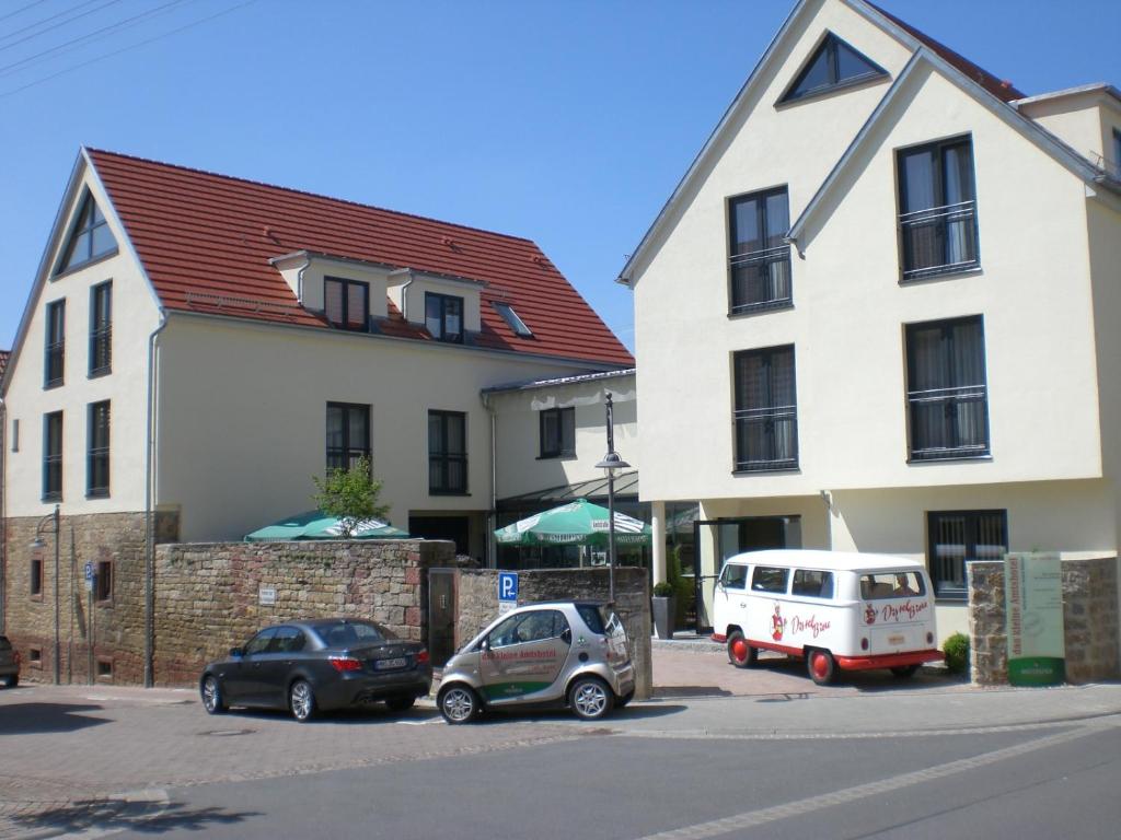 un par de autos estacionados en un estacionamiento al lado de un edificio en Das kleine Amtshotel, 