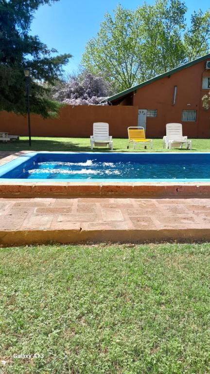 una piscina con due sedie in un cortile di Casa quinta con pileta a Santa Rosa