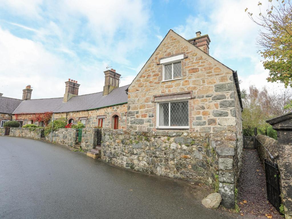 an old stone house with a window on a street at 5 The Crescent in Caernarfon