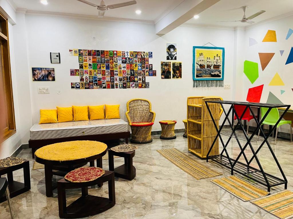Habitación con sofá, mesas y cuadros en la pared. en wuiD stayin wakeupinDoon en Dehradun
