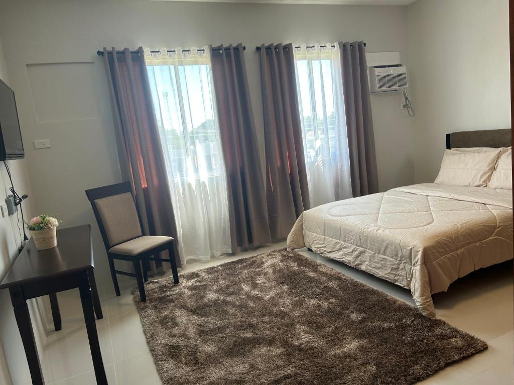 1 dormitorio con 1 cama, 1 silla y ventanas en Camella Manors Condo, IBIZA Bldg., en Bacolod