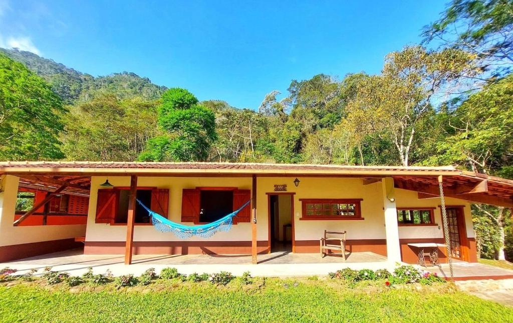 a house with a hammock in front of it at Sítio Abaetetuba - Toda Paz do Universo in Nova Friburgo