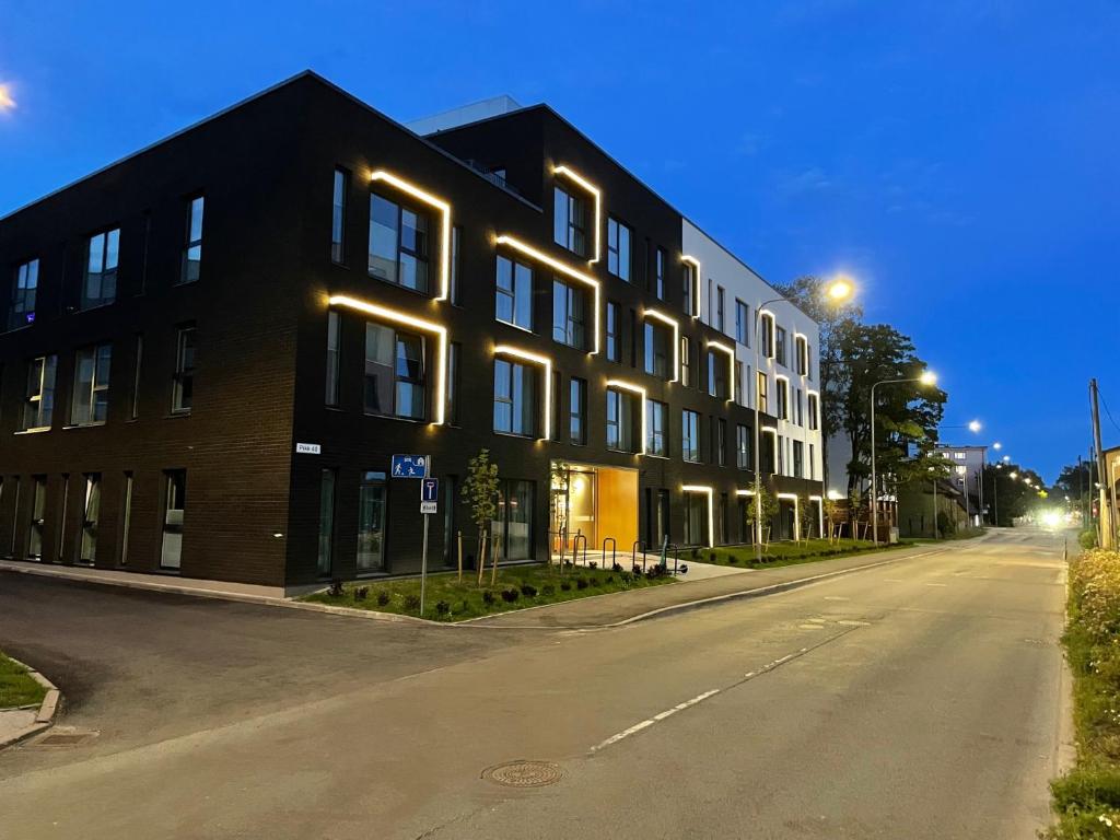 un edificio negro con luces en el lateral de una calle en Rare Apartments - Self Check-In Microapartments en Tartu