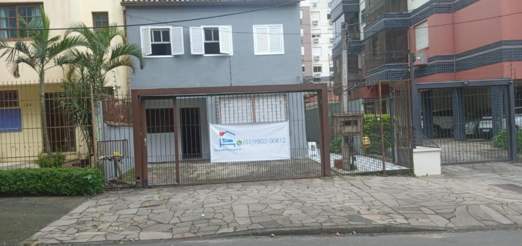 una valla delante de un edificio con un cartel en POUSADA ECONOMICA PORTO, en Porto Alegre