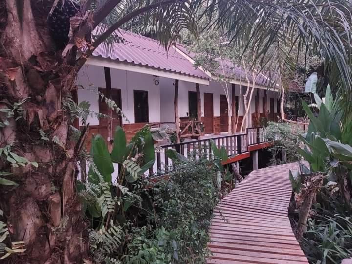 ein Haus mit einem Holzsteg davor in der Unterkunft สบายคันทรีรีสอร์ท ปากเมงSa-buy country resort Pak Meng in Sikao