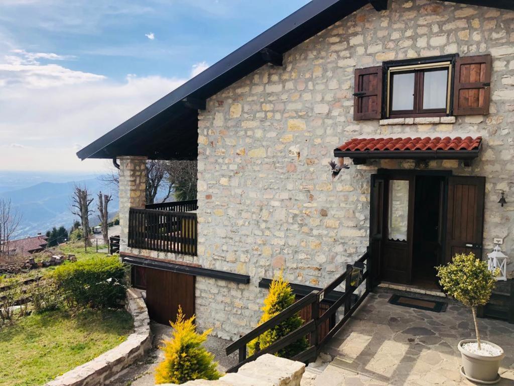 a stone house with a door and a balcony at Casa Emy in Adrara San Rocco