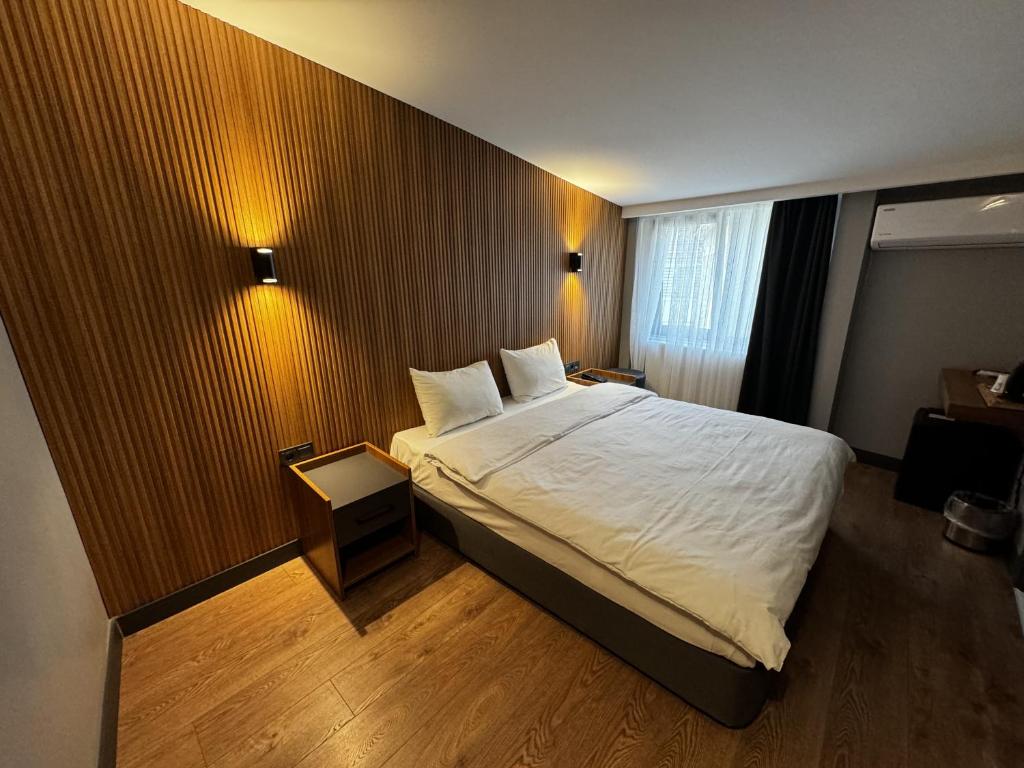 a bedroom with a large bed with white sheets at Bademi Room in Edirne