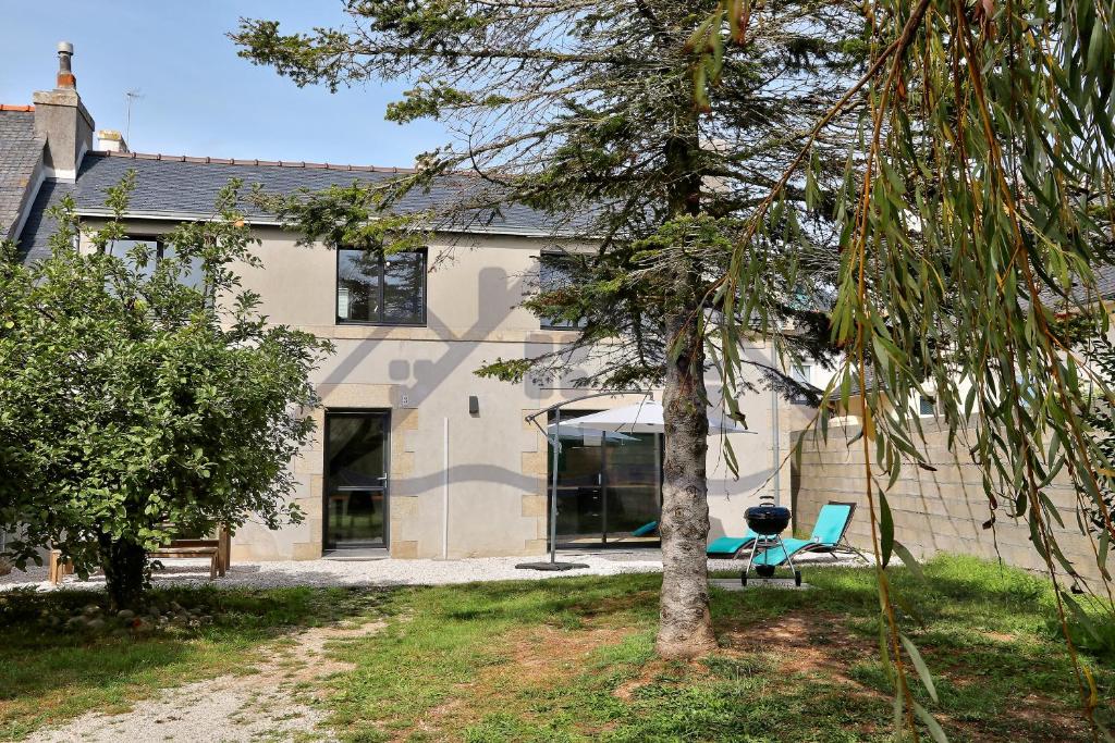 une maison avec un arbre en face dans l'établissement LocaLise - M3C - Maison entièrement rénovée en duplex avec jardin - Tout à pied, plage, port, centre, commerces - Wifi inclus - Draps inclus - Animaux bienvenus, au Guilvinec