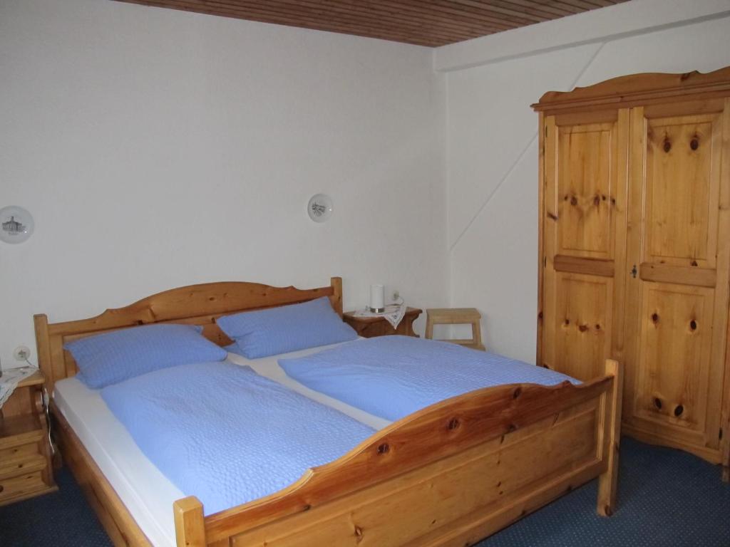 1 dormitorio con cama de madera y armario de madera en Gasthaus Adler, en Wangen im Allgäu