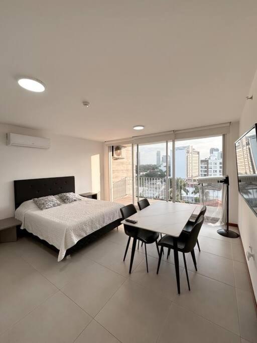 a bedroom with a bed and a table with chairs at Hermoso Loft Zona Shopping Sol 02 in Asunción