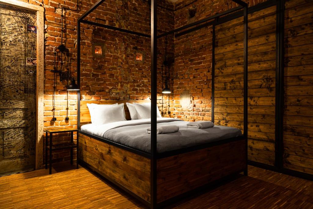 a bedroom with a bed in a brick wall at HOUSEHOST ApartmenI: Podbrzezie 2/20 in Krakow
