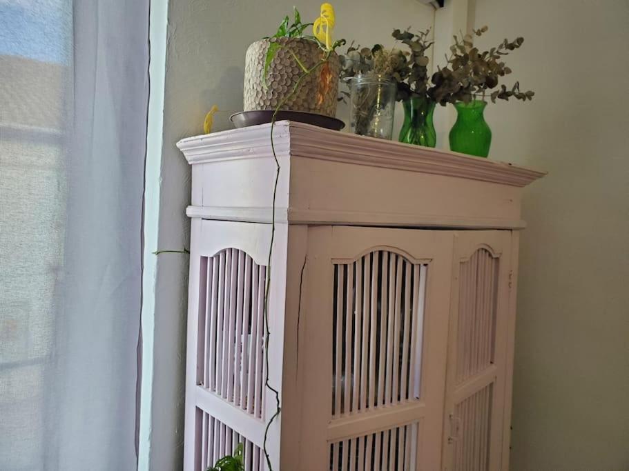 a wooden cabinet with a plant on top of it at Le Bohème in Sigean