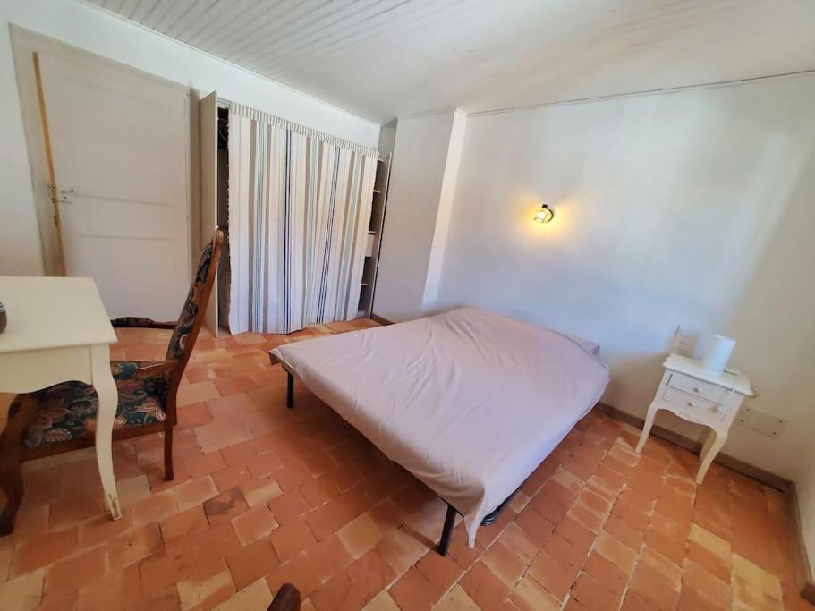 a bedroom with a bed and a table and a desk at Le Bohème in Sigean