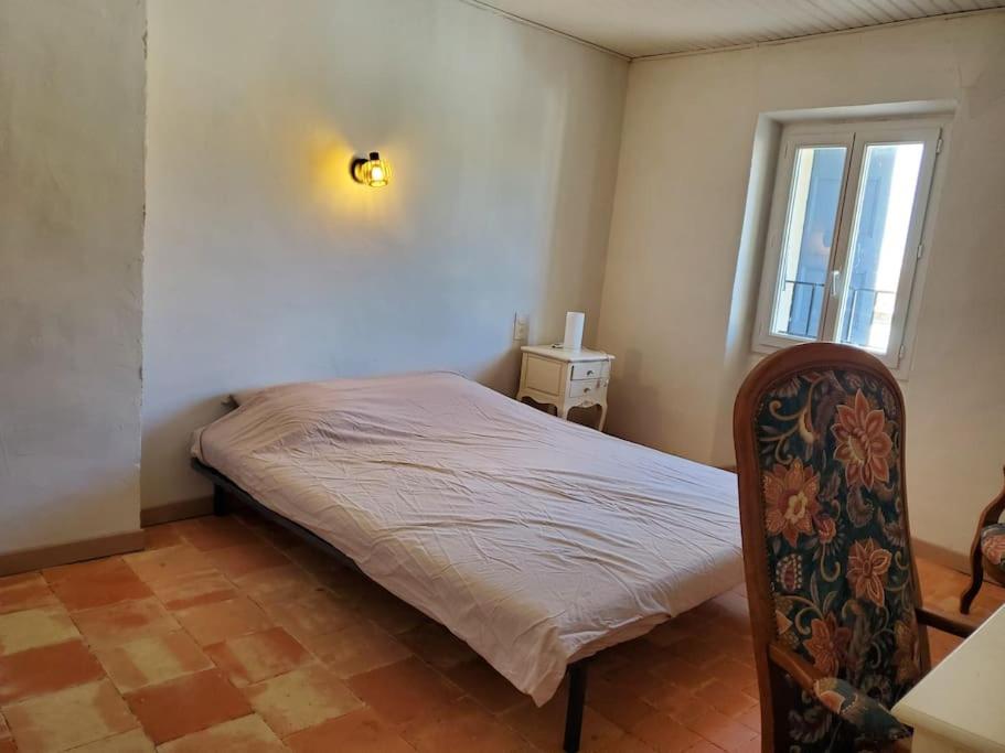 a small bedroom with a bed and a window at Le Bohème in Sigean