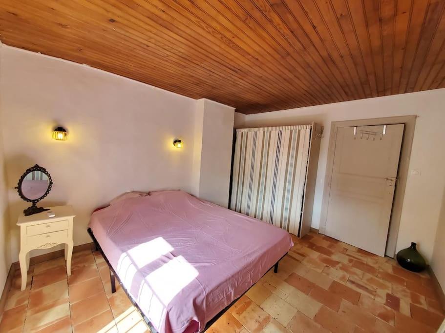 a bedroom with a bed and a wooden ceiling at Le Bohème in Sigean